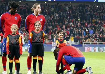 Griezmann atando las botas de un niño.