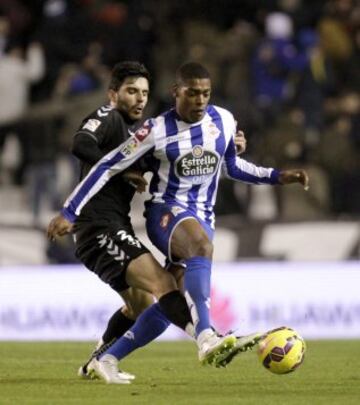 El defensa del Eibar Eneko Bóveda disputa un balón con el Portugués del Deportivo Ivan Cavaleiro.