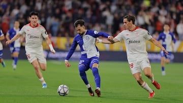 Oso y Manu Bueno intentan arrebatarle a Baena un balón.