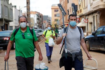 La gente lleva cubos y escobas, tras las fuertes lluvias que provocaron inundaciones, en Sedaví. 