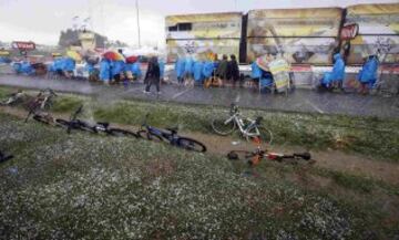 Espectadores de la etapa se protegen de la lluvia.