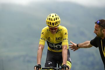 Un miembro del equipo de Sky ayudando a Christopher Froome una vez este ha cruzado la línea de meta.