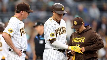 SAN DIEGO, CALIFORNIA - MAY 15: Manager Bob Melvin and trainer Ricky Huerta walk with Manny Machado #13 of the San Diego Padres after he was hit by a pitch on the wrist during the second inning of a game against the Kansas City Royals at PETCO Park on May 15, 2023 in San Diego, California.   Sean M. Haffey/Getty Images/AFP (Photo by Sean M. Haffey / GETTY IMAGES NORTH AMERICA / Getty Images via AFP)