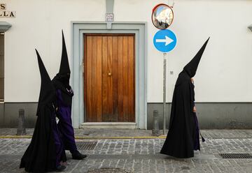 Varios nazarenos se dirigen a la Iglesia Parroquial de San Bernardo para realizar su estación de penitencia el Miercóles Santo de la Semana Santa 2025.