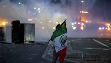 Un manifestante sostiene una bandera mexicana durante un enfrentamiento con la policía en el condado de Los Ángeles, California, EE. UU.