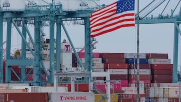 FILE PHOTO: A U.S. flag flutters near shipping containers as a ship is unloaded at the Port of Los Angeles, in San Pedro, California, U.S., May 1, 2025. REUTERS/Mike Blake/File Photo