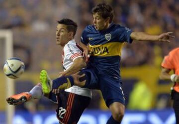 El jugador del Boca Juniors Marcelo Meli (d) disputa la pelota con el jugador del River Plate Sebastián Driussi (i).