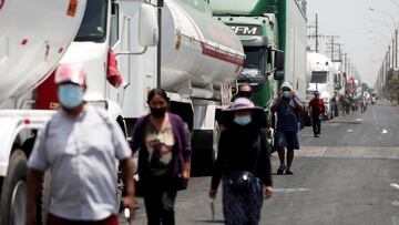 People walk next to parked trucks during a national transportation strike against fuel prices, in Lima, Peru March 18, 2021. REUTERS/Angela Ponce