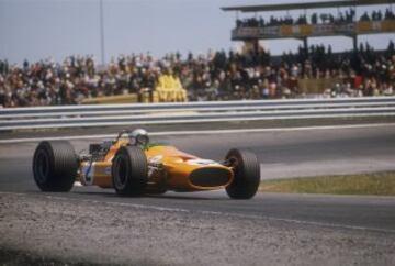 1968. Ése año McLaren quedaría por detrás de Lotus en el Mundial de Constructores, ganando Graham Hill el de pilotos. En la imagen el neozelandés Bruce McLaren durante el GP de España de 1968 en el Jarama con el M7A-Ford Cosworth con el tradicional color naranja.