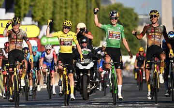 Los ciclistas del Jumbo-Visma, con Jonas Vingegaard y Wout van Aert al frente, celebran su éxito en el Tour en la meta de París.