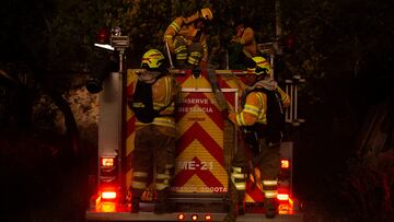 Firefighters get into a fire truck during emergency response to extinguish a forest fire on a hill in Bogota, Colombia January 24, 2024. REUTERS/Antonio Cascio