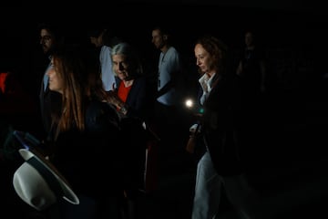 La gente usa la linterna de su tel¨¦fono para caminar por los pasillos oscuros durante un apag¨®n generalizado durante la s¨¦ptima jornada del Mutua Madrid Open en La Caja M¨¢gica.