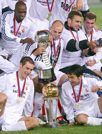 Iván Helguera y Raúl flanquean el trofeo de campeón de la Copa Intercontinental que el Real Madrid ganó en 2002. Roberto Carlos sostiene la Copa Toyota, que también se entregaba al vencedor.