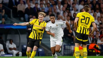 MADRID, 22/10/2024.- El centrocampista británico del Real Madrid Jude Bellingham (c) disputa un balón con el centrocampista alemán del Borussia Julian Brandt (i) durante el encuentro correspondiente a la fase regular de la Liga de Campeones entre Real Madrid y Borussia Dortmund, este martes en el estadio Santiago Bernabéu, en Madrid. EFE / Juanjo Martín
