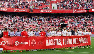 Ambos equipos posaron antes del partido con una pacarta que dice: 'Racistas, fuera del fútbol'.