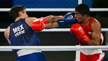 Uzbekistan's Asadkhuja Muydinkhujaev and Mexico's Marco Alonso Verde Alvarez (Blue) compete in the men's 71kg final boxing match during the Paris 2024 Olympic Games at the Roland-Garros Stadium, in Paris on August 9, 2024. (Photo by Mauro PIMENTEL / AFP)