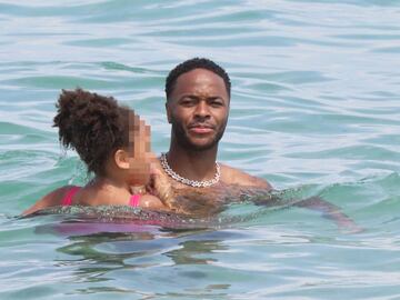 Please hide child&#039;s face prior to the publication - Raheem Sterling from Manchester City football club frolics with daughter in Saint Tropez at the Club 55 beach, Saint-Tropez, France on July 23, 2020.  