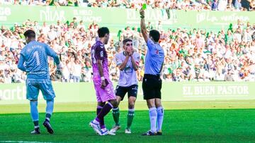 El árbitro amonesta a Reina tras tocar el balón fuera del área con las manos. Debió ser roja.