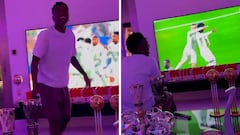 Vinicius casually games in a living room flooded with trophies