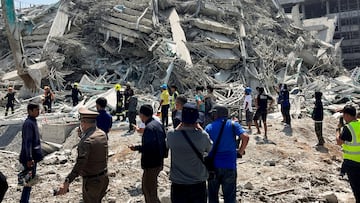 People stand near the site of a collapsed building after a strong earthquake struck central Myanmar on Friday, earthquake monitoring services said, which affected Bangkok as well with hundreds of people pouring out of buildings in the Thai capital in panic after the tremors, in Bangkok, Thailand, March 28, 2025. REUTERS/Ann Wang     TPX IMAGES OF THE DAY