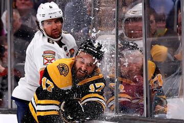 Boston Bruins y Florida Panthers protagonizaron un emocionante y disputado partido en la NHL en el que por momentos saltaron chispas. Como esta acción en la que el jugador de los Panthers Colin White (6) empuja contra el cristal a Nick Foligno (17) en el TD Garden de Boston (Massachusetts). El resultado final: 5-3 para los locales.