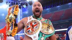 El campeón CMB de los pesos pesados Tyson Fury con sus cinturones.