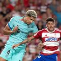 Barcelona's Uruguayan defender #04 Ronald Araujo (L) and Granada's Spanish defender #15 Carlos Neva jump for the ball during the Spanish league football match between Granada FC and FC Barcelona at the Nuevo Estadio de Los Carmenes in Granada on October 8, 2023. (Photo by JORGE GUERRERO / AFP)