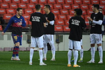 Los jugadores del Getafe realizaron el pasillo al Barcelona, campeón de la Copa del Rey. Los azulones salieron al campo con una camiseta contra la Superliga y con el mensaje: 'El fútbol es para los fans'. En la imágen Leo Messi y Nemanja Maksimovic.