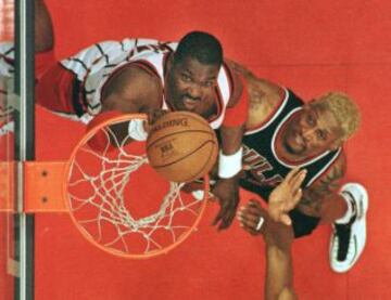 Comparte el r谷cord de la NBA, con 11 rebotes ofensivos en un partido, logrando la haza?a en dos ocasiones durante las Finales de la NBA de 1996. Aqu赤 pelea por el bal車n contra uno de los m芍s grandes de la Liga, Hakeem Olajuwon.