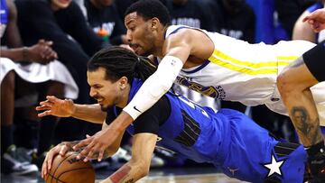 Otto Porter Jr., alero de Golden State Warriors, lucha por el balón con Cole Anthony, novato de Orlando Magic.