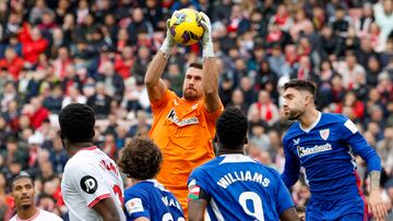 SEVILLA , 16/03/2025.- El portero del Athletic Unai Simón (detrás) atrapa el balón durante el partido de LaLiga entre el Sevilla y el Athletic Club, este domingo en el estadio Ramón Sánchez Pizjuán. EFE/ Julio Muñoz