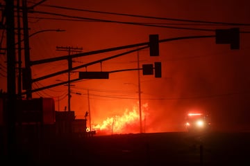 Un camin de bomberos pasa junto a las llamas a lo largo de la Pacific Coast Highway, mientras un incendio forestal arde en el vecindario de Pacific Palisades en el oeste de Los ?ngeles.