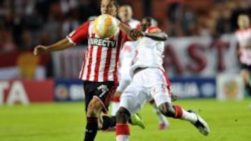 Carlos Auzqui (i) de Estudiantes ante Dairon Mosquera (d) de Independiente Santa Fe.