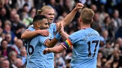 Manchester City's Norwegian striker Erling Haaland (C) celebrates with Manchester City's Algerian midfielder Riyad Mahrez (L) and Manchester City's Belgian midfielder Kevin De Bruyne after scoring the opening goal during the English Premier League football match between Manchester City and Brighton and Hove Albion at the Etihad Stadium in Manchester, north west England, on October 22, 2022. (Photo by Oli SCARFF / AFP) /