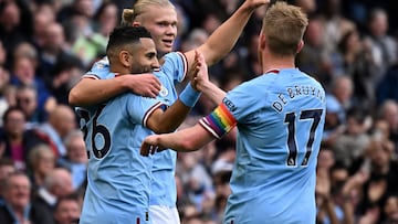 Manchester City's Norwegian striker Erling Haaland (C) celebrates with Manchester City's Algerian midfielder Riyad Mahrez (L) and Manchester City's Belgian midfielder Kevin De Bruyne after scoring the opening goal during the English Premier League football match between Manchester City and Brighton and Hove Albion at the Etihad Stadium in Manchester, north west England, on October 22, 2022. (Photo by Oli SCARFF / AFP) /