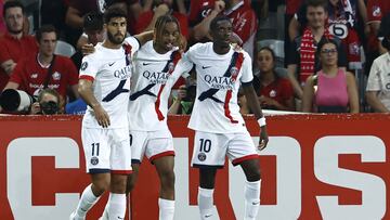 Paris Saint-Germain's French forward #29 Bradley Barcola (C) celebrates with Paris Saint-Germain's Spanish forward #11 Marco Asensio (L) and Paris Saint-Germain's French forward #10 Ousmane Dembele (R) after scoring PSG's second goal during the French L1 football match between Lille LOSC and Paris Saint-Germain (PSG) at the Stade Pierre-Mauroy in Villeneuve-d'Ascq, northern France, on September 1, 2024. (Photo by DENIS CHARLET / AFP)