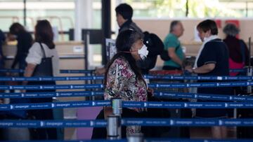 A passenger wears a protective face mask to prevent the spread of the new Coronavirus, COVID-19, at the Arturo Merino Benitez International Airport, in Santiago, on March 14, 2020. (Photo by CLAUDIO REYES / AFP)