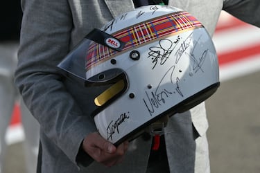 Sir Jackie Stewart, tricampeón de F1, con el casco firmado por Michael Schumacher y todos los campeones del mundo vivos. El casco será subastado para recaudar fondos para la investigación de la demencia.