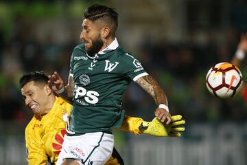 El jugador de Santiago Wanderers Marco Medel, centro, disputa el balon con Leandro Castellanos de Independiente de Santa Fe durante el partido de tercera fase de la Copa Libertadores en el estadio Elias Figueroa de Valparaiso, Chile.