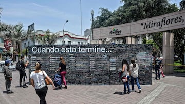 People surround a giant blackboard where antyone can write what they want to do when the new coronavirus pandemic is over, in Lima on October 26, 2020. - On giant blackboards placed in two squares in Lima, people can write with colored chalk what they want to do &quot;when this is over.&quot; (Photo by ERNESTO BENAVIDES / AFP)