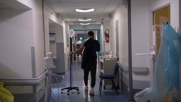 A patient walks along the corridor of the emergency unit of the Saint Camille hospital in Bry-sur-Marne, a suburb of Paris, on January 21, 2022. 