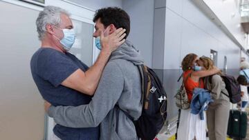 A man (L) receives a relative who arrived from Seville, upon his arrival at Tenerife Sur Airport, which has been opened for travelers from most of Europe after lifting the State of Emergency and lockdown to stop the spread of the coronavirus, in Tenerife,