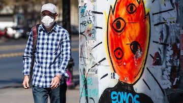 A man wears a face masks as a precautionary measure against the spread of the new coronavirus, COVID-19, as he walks outside a Hospital in Santiago, Chile, march 23, 2020. - Chile declared a "state of catastrophe" and delayed a constitutional referendum while several countries announced nighttime curfews as Latin America expanded its coronavirus lockdown. (Photo by Martin BERNETTI / AFP)