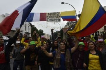 French and Colombian supporters wave flags under a sign reading "Nairo our champion" near the departure village during the 109,5 km twenty-first and last stage of the 102nd edition of the Tour de France cycling race on July 26, 2015, between Sevres and Paris.  AFP PHOTO / JEFF PACHOUD