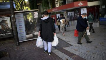 Un hombre lleva varias bolsas de supermercado en la zona b&aacute;sica de salud de Guzm&aacute;n el Bueno, en el distrito de Chamber&iacute;, en Madrid (Espa&ntilde;a), a 26 de octubre de 2020. Guzm&aacute;n el Bueno es una de las zonas b&aacute;sicas de 