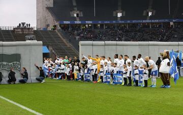 A la salida de los jugadores comenzó la performance en el que se simuló la caída del falso muro.