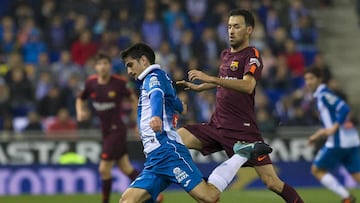 Sergio Busquets y Gerard Moreno disputando un balón.
