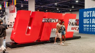 Unos aficionados posan en el UFC X junto a una de sus atracciones.
