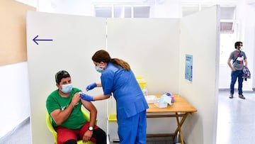 An agricultural worker receives a jab of the J&J/Janssen Covid-19 vaccine at a vaccination centre in Alcarras, near Lleida, on May 22, 2021. - Spain, a key provider of fresh fruit and vegetables to the rest of Europe, is racing to immunise the army of cheap labour that follows the ripening of different crops across the country as the harvest season nears. (Photo by Pau BARRENA / AFP)