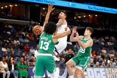 John Konchar de los Memphis Grizzlies penetra hacia la canasta mientras el alero de los Boston Celtics, Ronald Harper, y el base Hugo González defienden durante el tercer cuarto en el FedExForum.